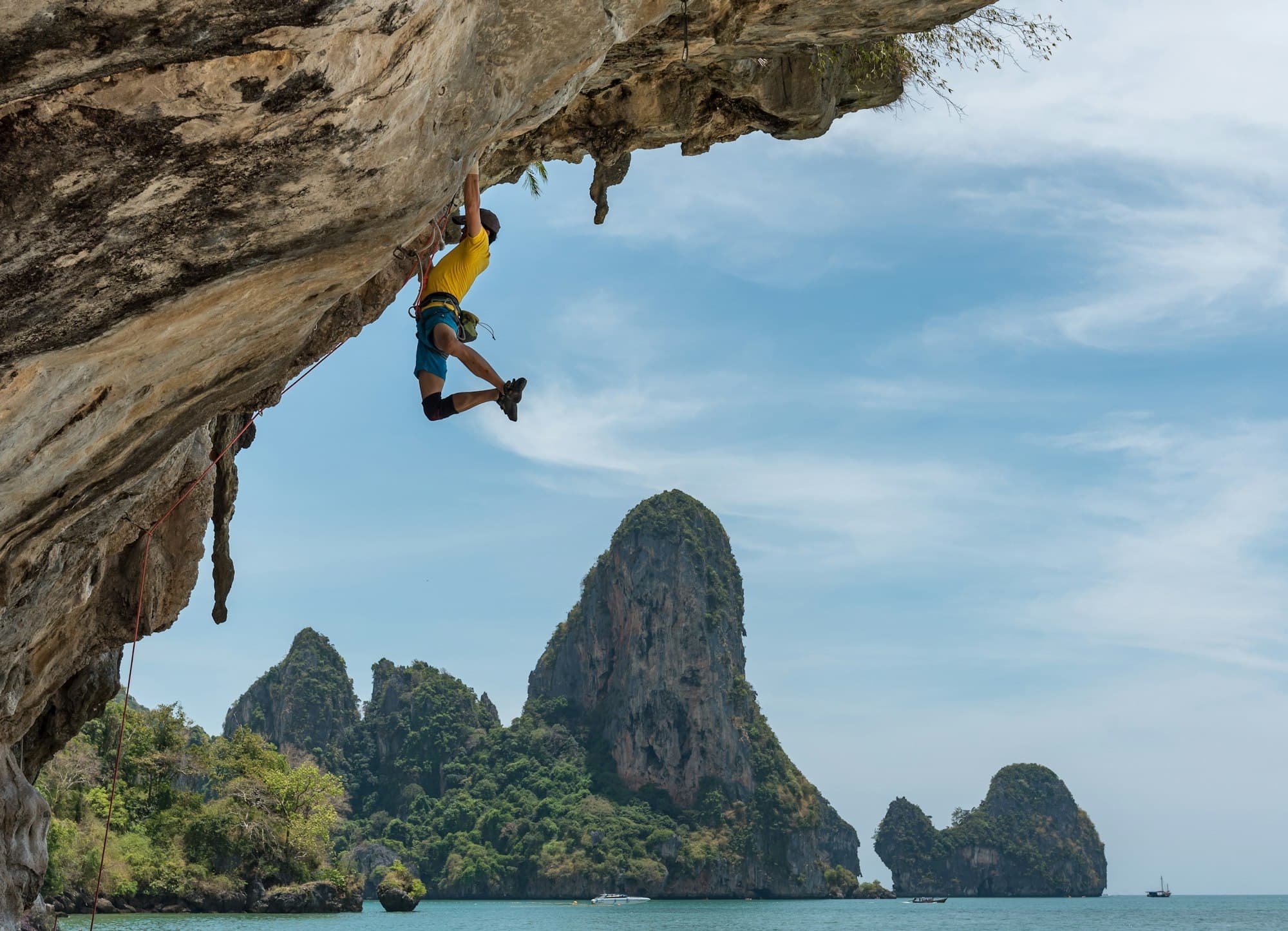 Climber hanging from an overhanging sea cliff above the ocean